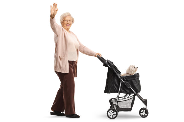 一个快乐的老妇人推着一辆婴儿车挥手图片下载