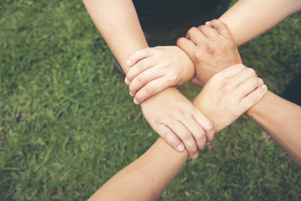 一群多元化的人握着手一起碰拳，力量十足的tag团队。团队合作:多种族的人在一起工作。商务人士团队携手成功。商务会议图片下载