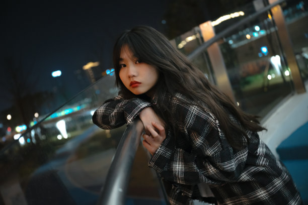 亚洲孤独的女孩靠在桥栏杆的夜晚图片下载