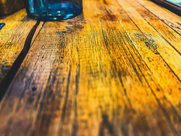 这是一幅带有深色纤维和玻璃底部的浅色木材的微距图像。图片下载