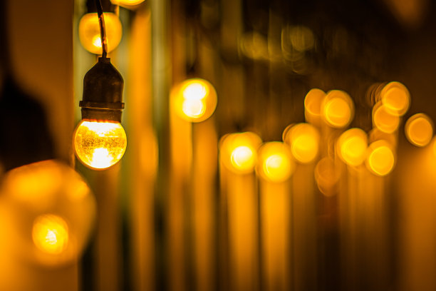 装饰悬挂黄橙灯与模糊的灯光黑暗的夜晚背景图片下载