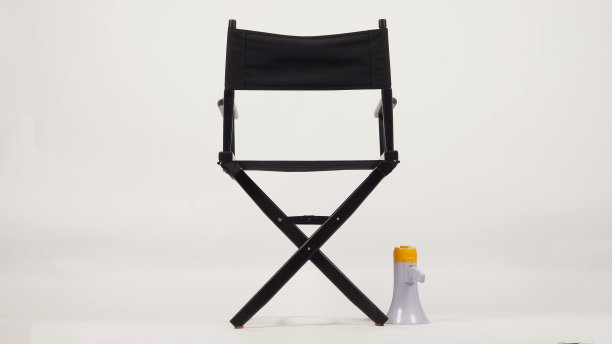 黑色导演椅背和扩音器放在白色背景的地板上。图片下载