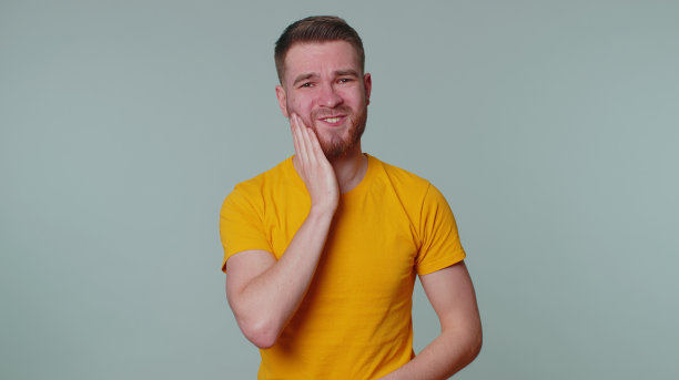 因牙痛、蛀牙或牙龈炎等而触摸脸颊的男子图片下载