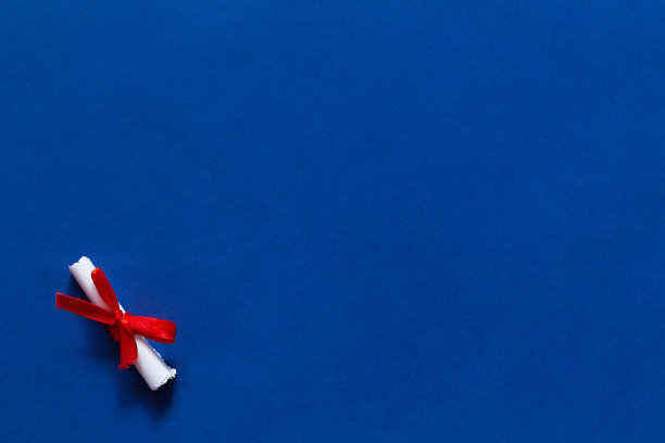 明信片。蓝色背景的礼物卡片。贺卡和红色天鹅绒袋与复制空间的文本。前视图。祝贺滚动与红丝带在蓝色的背景。图片下载