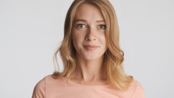 年轻美丽的女人摆姿势在相机孤立在白色的背图片下载