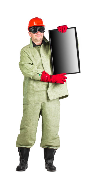 一个穿着防护服的焊工手里拿着一个显示器。图片下载