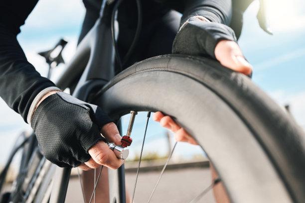 剪裁镜头的一个无法辨认的人检查他的轮胎在户外骑车图片下载