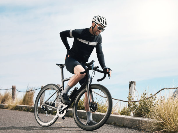 一个英俊的成熟男人在户外骑自行车时休息的全长镜头图片下载