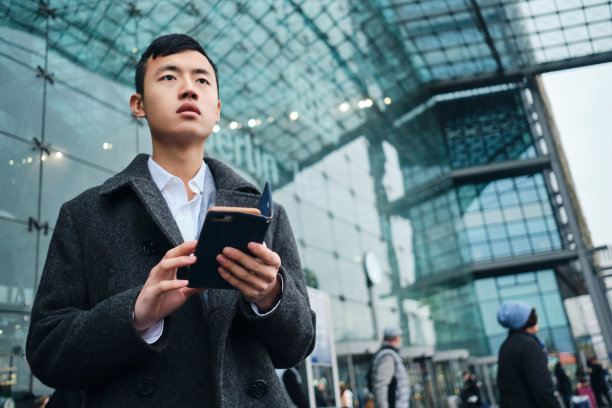 年轻时尚的商人，带着智能手机，在机场附近等待图片下载
