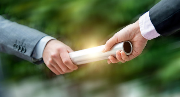 商界人士在户外传递接力棒图片下载