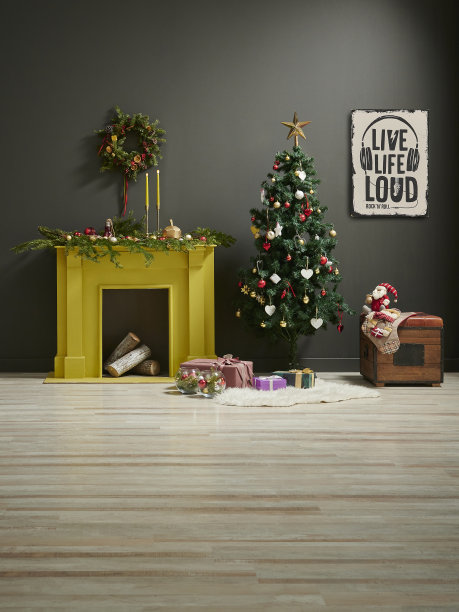 圣诞新年风格在灰色房间用黄色壁炉、椅子礼盒和装饰品装饰。图片下载