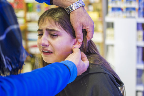 漂亮的女孩正在打耳洞图片下载
