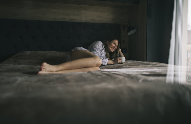 微笑的女人喜欢在床上放松周末图片下载