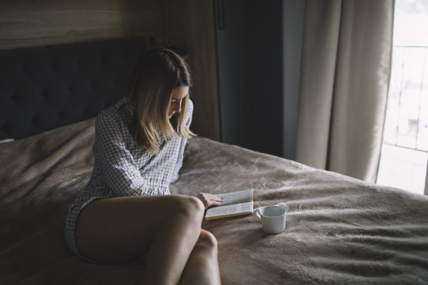 女人坐在床上看书图片下载