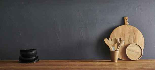 厨房装饰用科技工具电脑笔记本电脑，木制桌子风格用砧板、刀、勺、叉，灰色石墙。图片下载