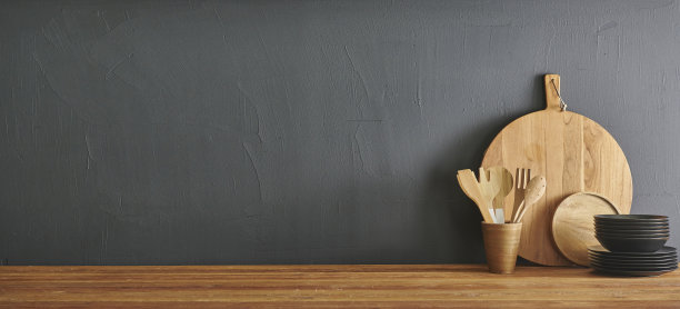 厨房装饰用科技工具电脑笔记本电脑，木制桌子风格用砧板、刀、勺、叉，灰色石墙。图片下载
