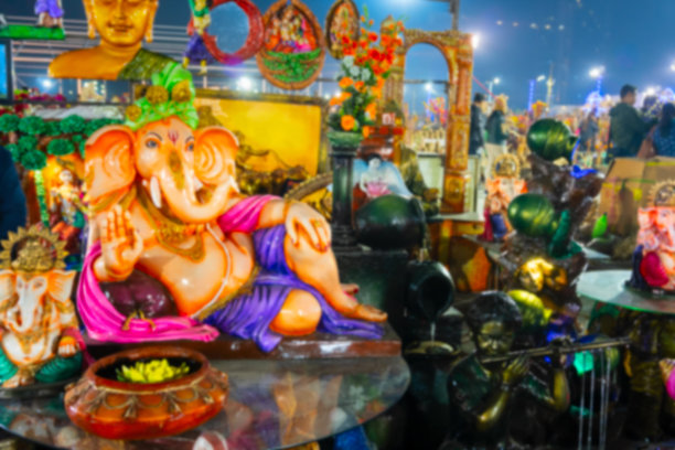 印度西孟加拉邦加尔各答的模糊图像。彩色的甘尼萨主与祝福的手在休息姿势，陶土娃娃展示，在Krishnanagar, Nadia。手工艺品展销。图片下载