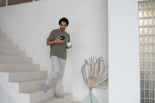 一个年轻人边喝茶边用手机发短信图片下载