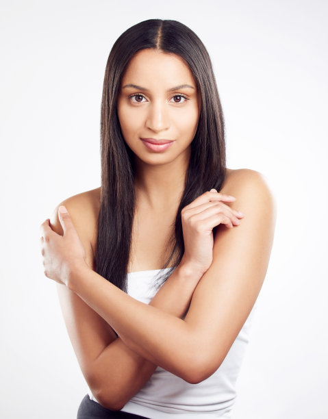 这张照片拍摄的是一名年轻女子，在白色的背景下摆姿势，头发看起来很健康图片下载