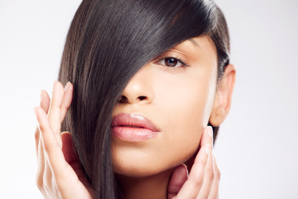 这张照片拍摄的是一名年轻女子，在白色的背景下摆姿势，头发看起来很健康图片下载