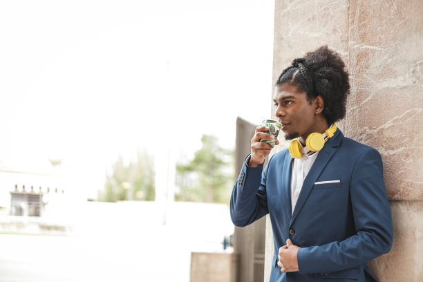 时尚的非裔美国商人在户外喝咖啡，白色的复印空间图片下载