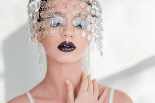 时尚美女特写肖像的女孩与黑色光泽的嘴唇，蓝色的眼影。皇冠的晶体图片下载