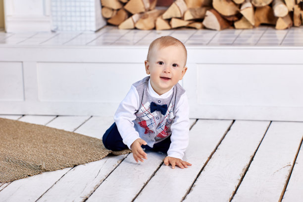 白色的木板地板，婴儿爬在上面。图片下载