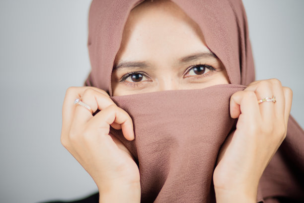 亚洲穆斯林妇女的特写肖像，用围巾遮住她的脸的一半图片下载
