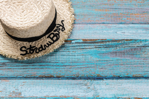 浅蓝色木制背景的草帽，沙滩和夏天的概念。图片下载