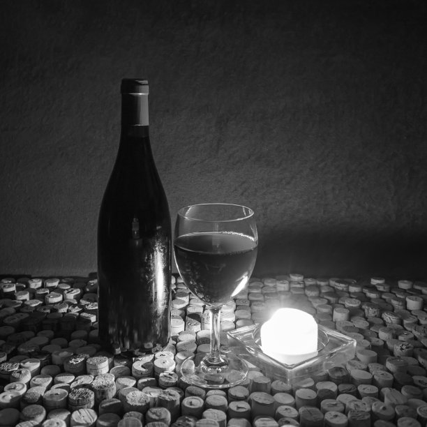 酒瓶，酒杯和燃烧的蜡烛，黑白相间图片下载