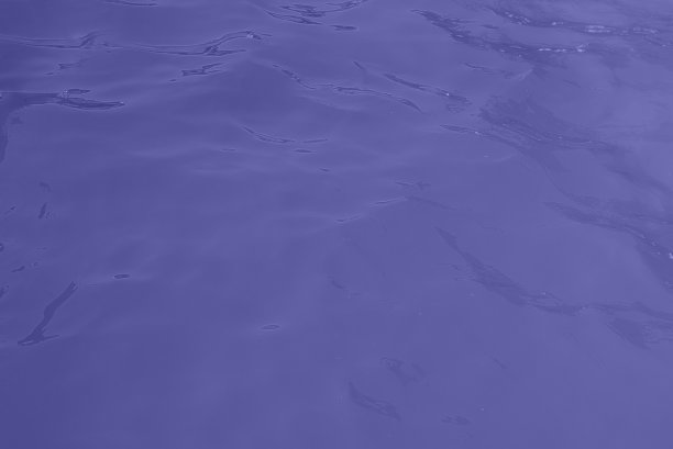 蓝色水波纹理背景。起涟漪的水。闪亮的紫色和蓝色的水面。图片下载