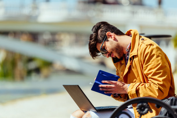 穿着黄色外套的漂亮商人在笔记本上写字图片下载