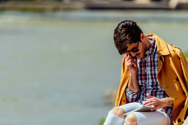 穿着黄色外套的时髦男人在城市的地方打电话图片下载