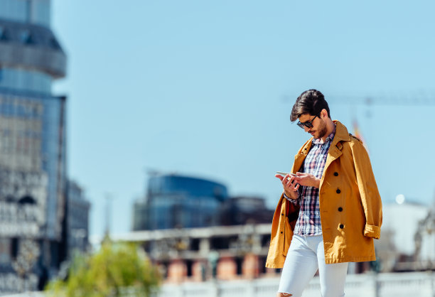 一个年轻人在城市广场用平板电脑发短信图片下载