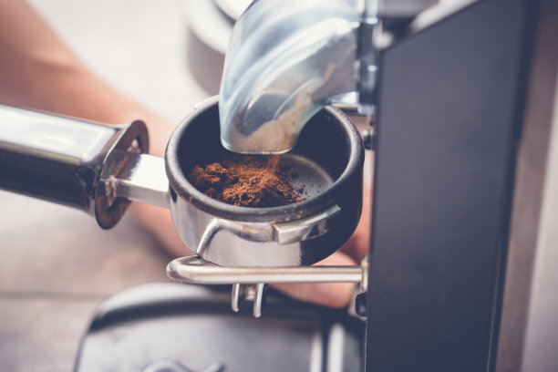 将磨碎的咖啡从研磨机倒入混合过滤器，特写镜头图片下载