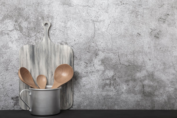 厨房复古的背景。铝制古董杯，木质砧板和勺子，厨房用具放在桌子上。家居用品、餐具正面观图片下载