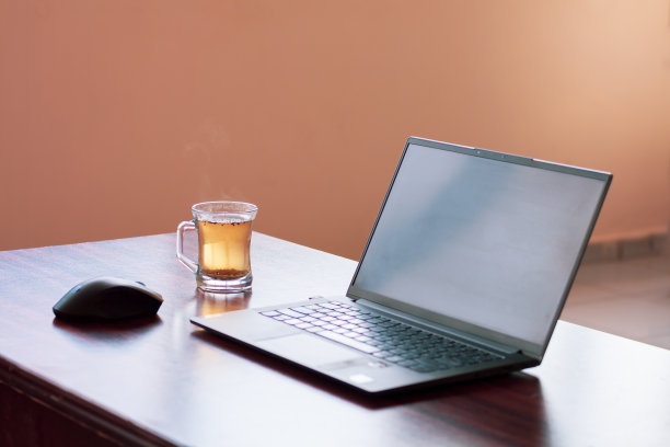 在家里工作的概念与笔记本电脑和茶缸在桌子上与选择性的焦点在马克杯。副本的空间。水平的照片。图片下载