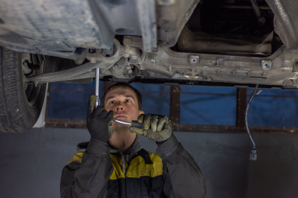 在汽车下面工作的汽车修理工图片下载