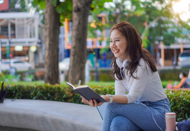 年轻的亚洲校园学生拿着虎皮进行户外教育和大学概念图片下载