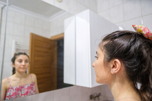 年轻女人看镜子里模糊的倒影图片下载