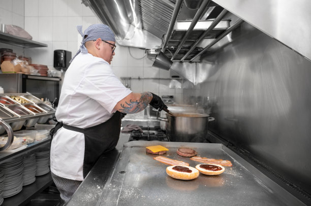 汉堡餐厅。女厨师在厨房烹饪汉堡。高质量的照片图片下载