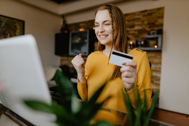 微笑的女人用信用卡在家网上购物图片下载