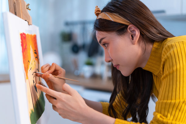 亚洲年轻有才华的女艺术家在画板上作画。吸引人的美丽女性画艺术图画，创作艺术品水彩画和画笔享受创作活动在家里。图片下载