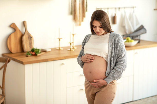一个怀孕的年轻女人在家里的肖像图片下载