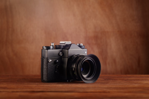 单反单镜头反射专业相机在木桌和背景图片下载