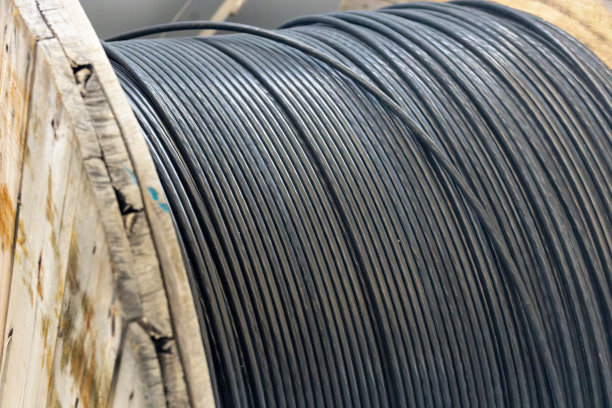 新的蓝色电源线缠绕在木线圈上。背景图片下载