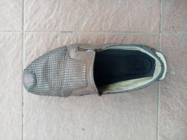 地板上有一只棕色的皮拖鞋图片下载