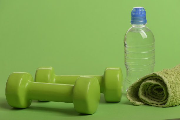亮绿色的哑铃，水瓶和布图片下载