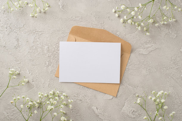 俯视图照片的妇女的一天组成牛皮纸信封信件和白色的gypsophila花在孤立的纹理灰色混凝土背景copyspace图片下载