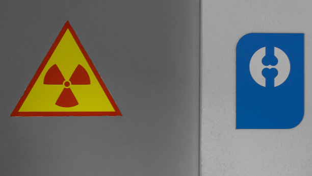 在上锁的门和墙上张贴x光警告标志。门上黄色的放射性标志。x射线内阁。图片下载